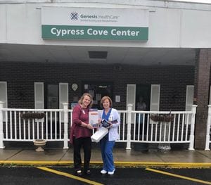 Genesis HealthCare Administrator and the Director of Nursing stand outside their facility with the donated supplies from Decatur Plant
