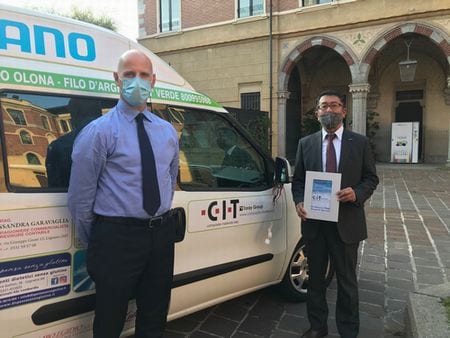 CIT President Shuji Kitabayashi (right) and Alberto Galli (left) stand in front of the nursing care service vehicle with CIT’s logo at the ceremony