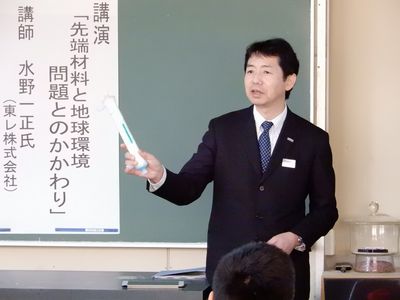 Mizuno speaking to the students with a sample of hollow-fiber membrane for hemodialysis in his hand