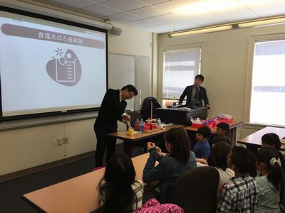 Iwasawa showing the children the filtration experiment using orange juice