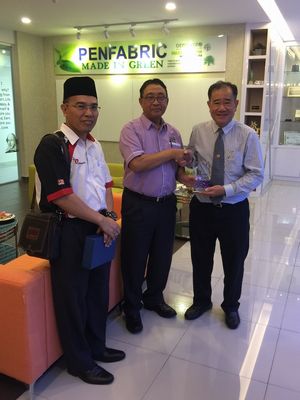 Teh (far right) receiving souvenir plaque from Tuan Haji Suimi (center)