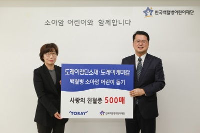 Kim (left) donating the 500 blood donation certificates to the Korea Childhood Leukemia Foundation