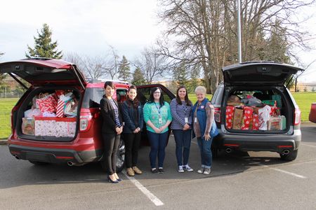 Members from General Affairs and Bethel Community Connections pose for a photo in front of two overstuffed SUVs!