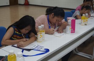 Children engrossed in writing letters to convey their gratitude to their parents